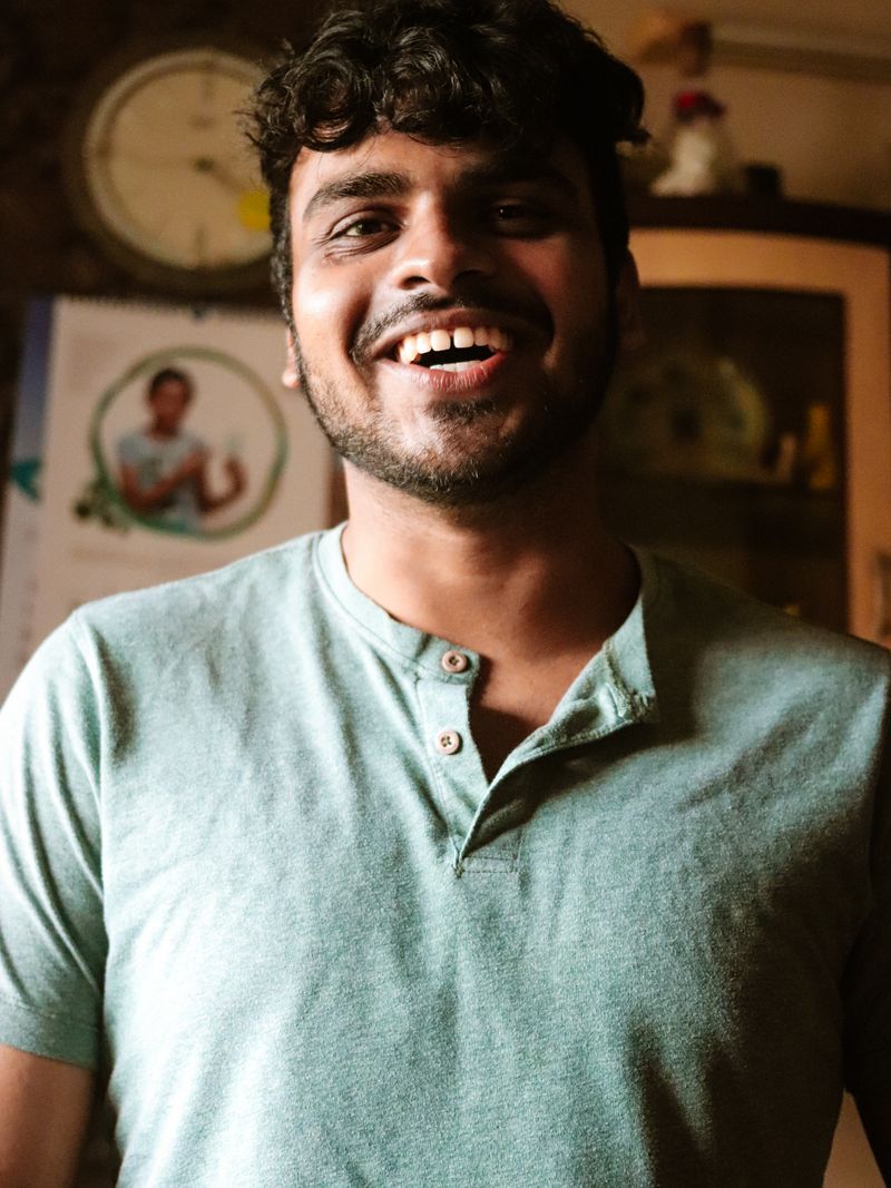 Representative portrait — Portrait of a joyful young man with a beard in a casual indoor setting, exuding happiness.