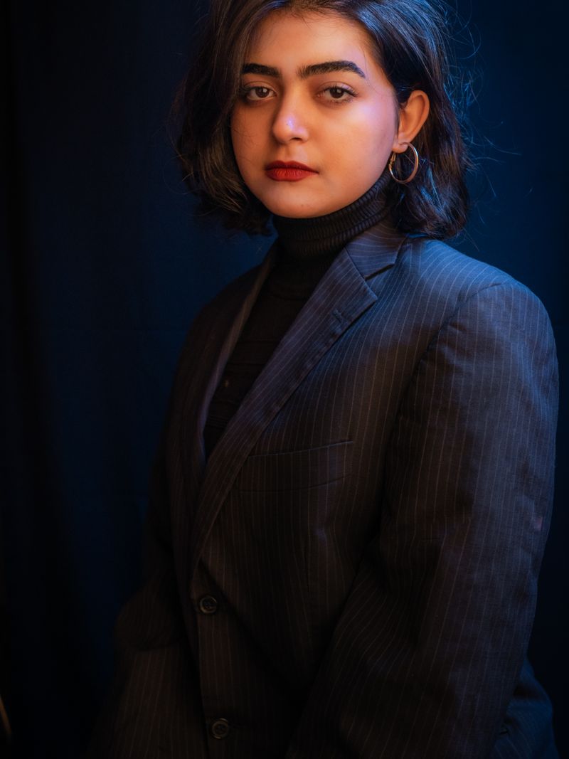 Representative portrait — A sophisticated portrait of a woman wearing a formal suit, captured with dramatic lighting.