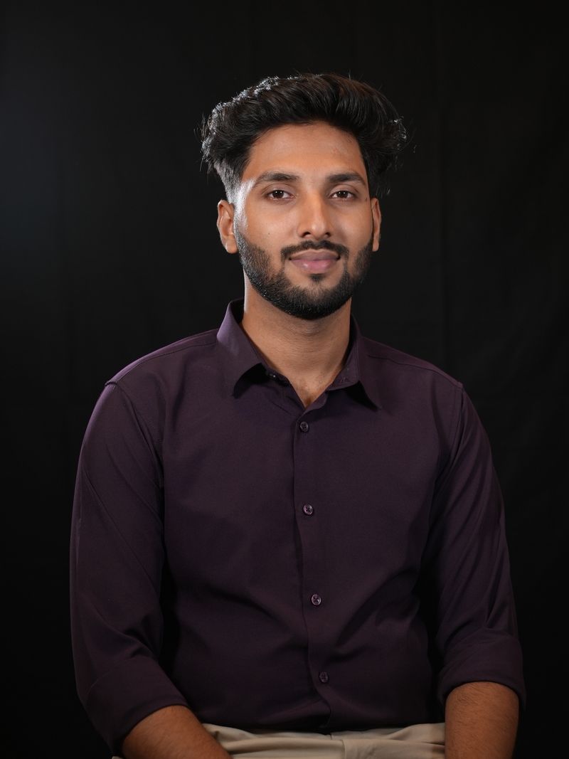Representative portrait — Studio portrait of a confident young man in a maroon shirt, exuding professionalism and style.